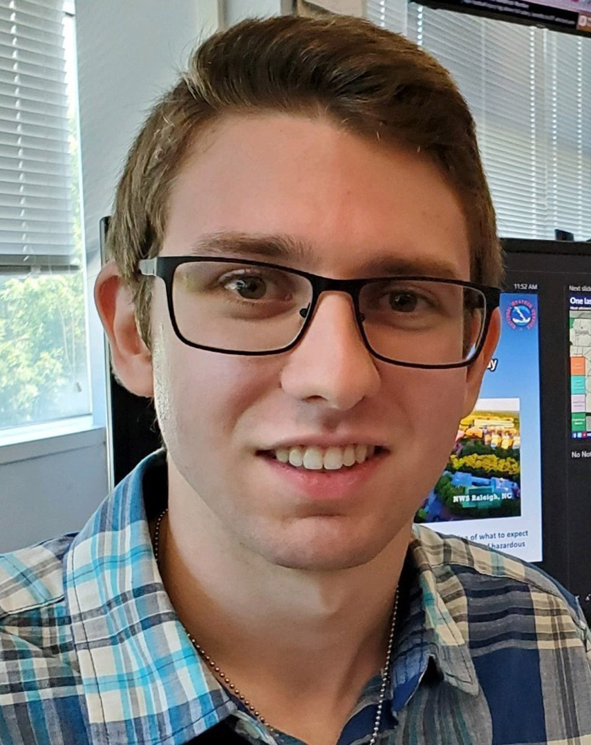 Picture of a young man with glasses smiling in an office