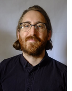 Picture of a white man with a beard wearing glasses